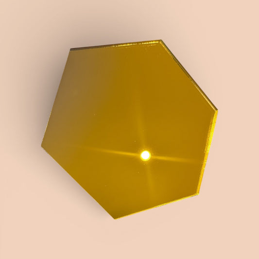 Hexagonal gold mirror acrylic blank on a beige background